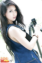 Adjusting tripod looking over her shoulder long hair down her back