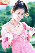 Tar Chang pulling dress from her shoulders wearing necklace
