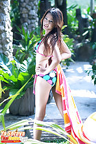 Ya Soraya with hands on hips looking over her shoulder long hair wearing bikini